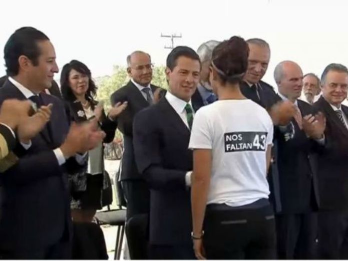 Nos faltan 43: protesta investigadora de la UNAM galardonada , frente a Peña Nieto